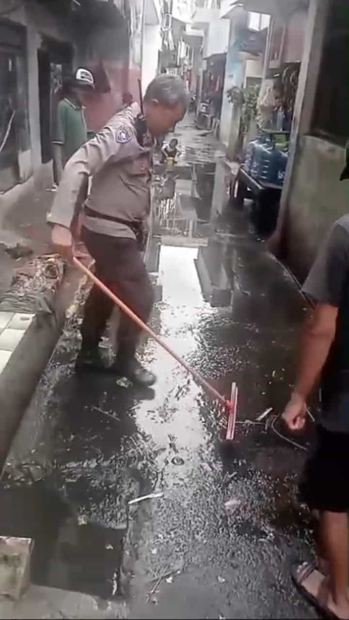 Aksi Bhabinkamtibmas Kedoya Selatan Bantu Warga Bersihkan Sisa Banjir di Kedoya Selatan