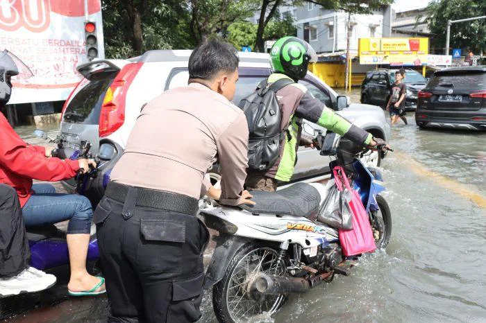 Aksi Humanis Polisi di Jakbar, Bantu Warga Melintas di Tengah Genangan Banjir, sejumlah personel Sat Samapta Polres Metro Jakarta Barat langsung turun ke lapangan untuk membantu masyarakat
