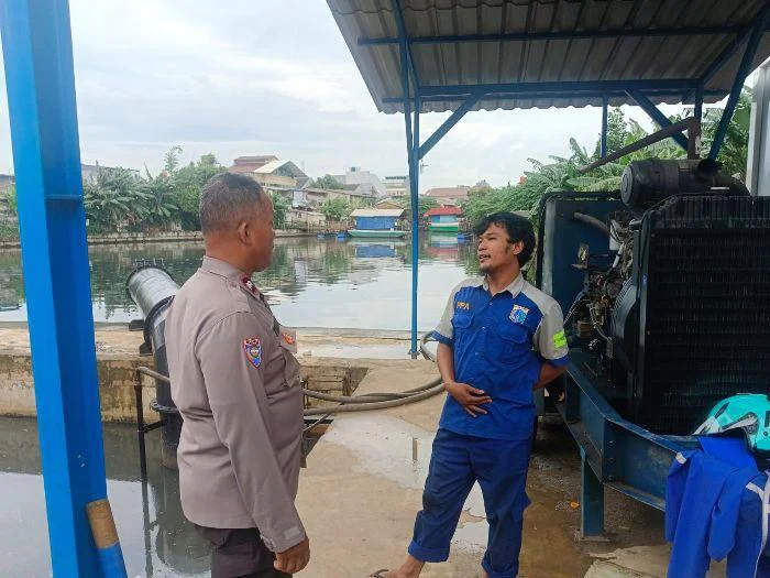 Bhabinkamtibmas Kelurahan Kedoya Utara Polsek Kebon Jeruk Polres Metro Jakarta Barat, Aiptu Turyono, koordinasi dengan petugas jaga pompa air di kawasan Pesing Garden, RT 011 RW 08, Kedoya Utara, Kebon Jeruk, Jakarta Barat.