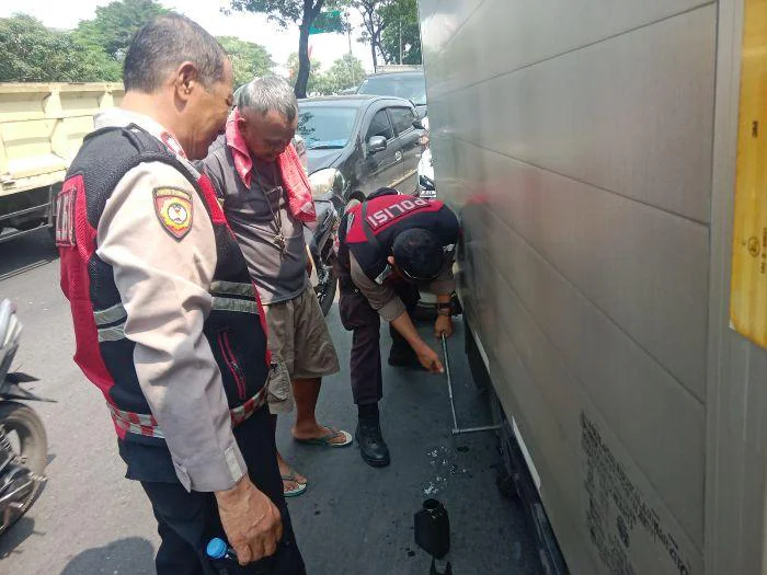 Personel Unit Samapta Polsek Kalideres Polres Metro Jakarta Barat saat melaksanakan patroli kewilayahan, Sigap Bantu Pengemudi Truk Box Pecah Ban Senin (18/5/2026) siang.
