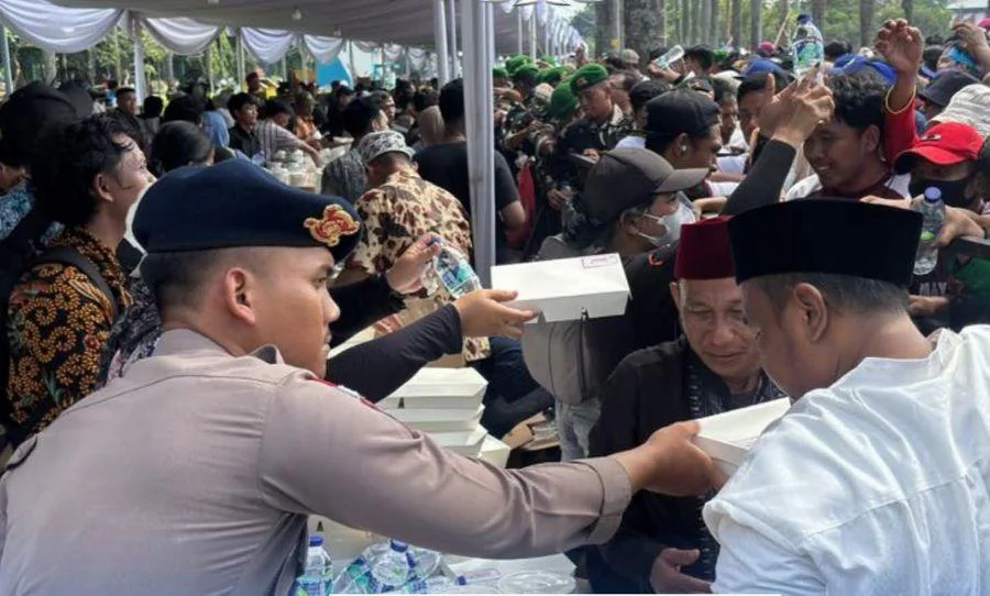 Personel Brimob Polda Metro Jaya membagikan nasi kotak,disiagakan di sejumlah titik strategis kawasan Monas untuk mendukung kelancaran kegiatan.